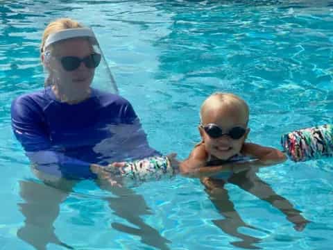 a person and a baby in a pool