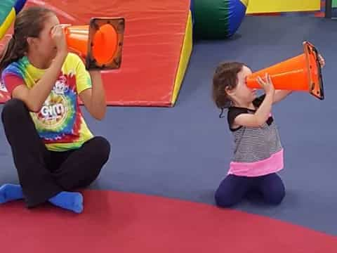 a couple of children playing on a red carpet in a room