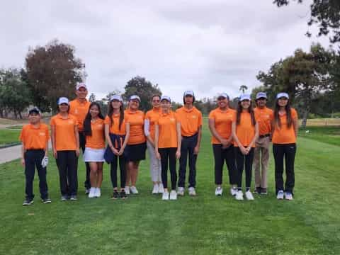 a group of people wearing matching orange shirts