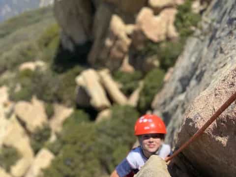a boy climbing a rock wall