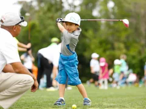 a boy swinging a golf club