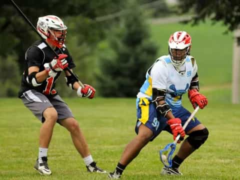 a couple of men playing lacrosse