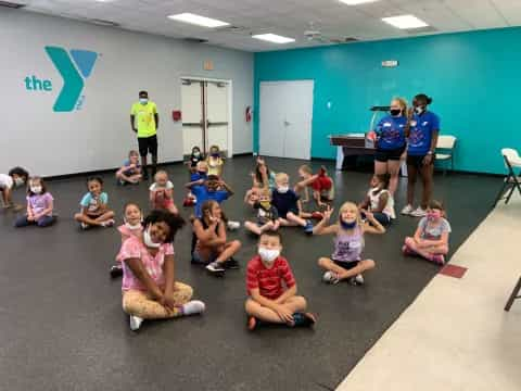 a group of children sitting in a circle in a room