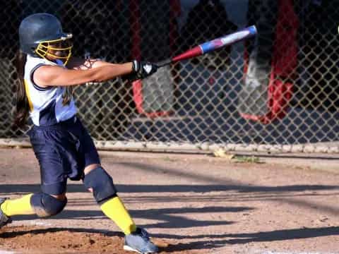 a girl swinging a baseball bat