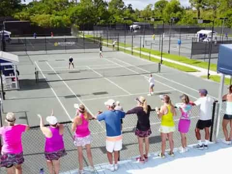 a group of people playing tennis