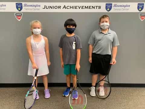 a group of kids with tennis rackets