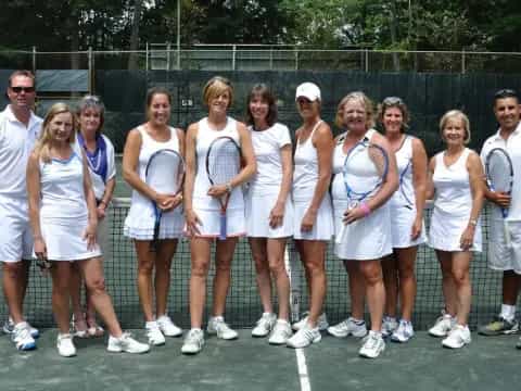 a group of people pose for a photo with tennis rackets
