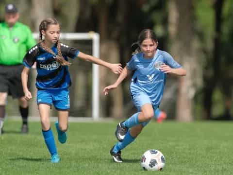 girls playing football on a field