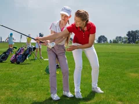 a couple of women playing golf