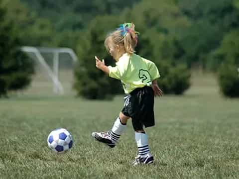 a little girl playing football