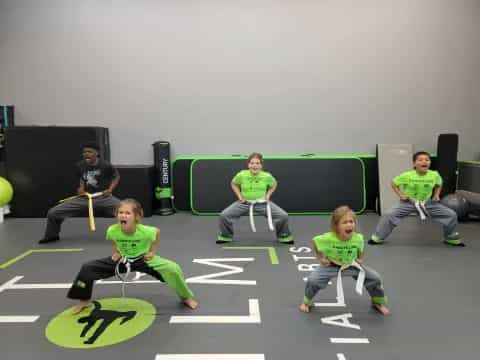 a group of people sitting on a mat with green and yellow arrows