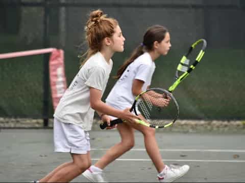 girls playing tennis on court