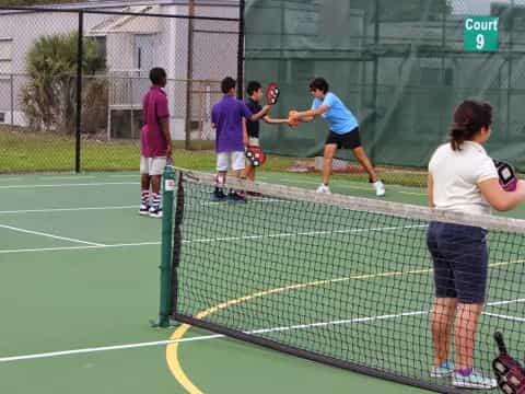 a group of people play tennis