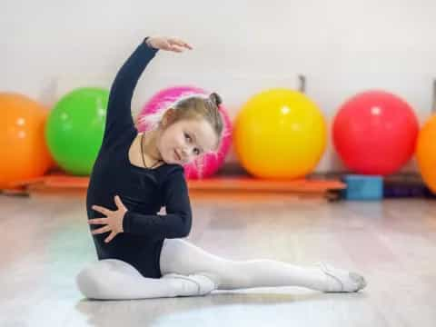 a girl with her arms up and a bunch of balloons