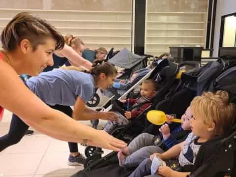 a woman pushing a group of children in a wheelchair