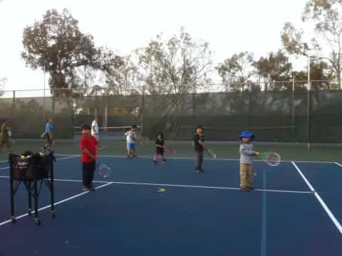 kids playing tennis on a court