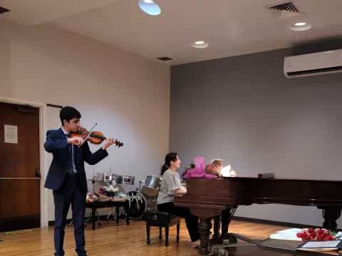 a person playing a violin in front of a group of people