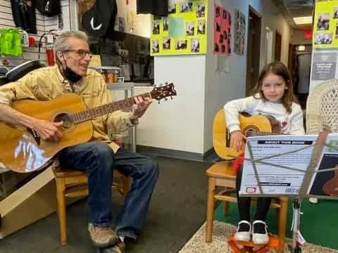 a person and a girl playing guitars