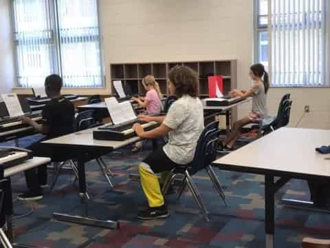 a group of people sitting at desks with laptops