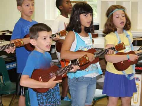 a group of children playing guitars