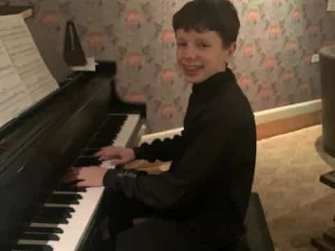 a boy playing a piano