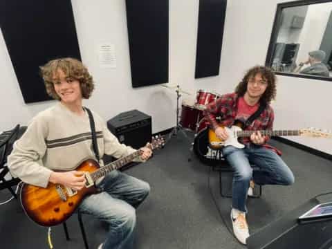 a couple of men playing guitars