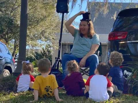 a person sitting on a chair with children around the