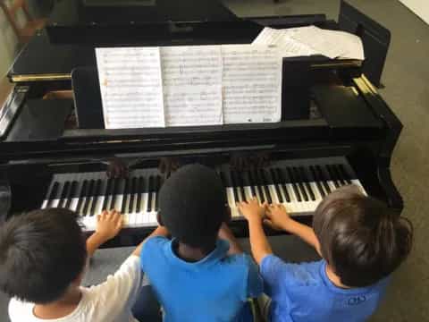 a group of kids playing piano
