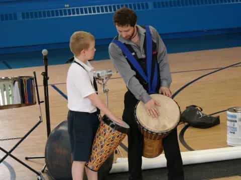 a person and a boy playing drums