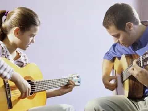 a boy and girl playing guitar