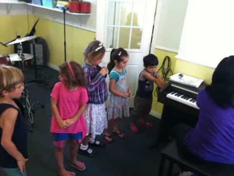 a group of children playing piano