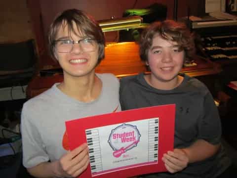 two boys holding a book