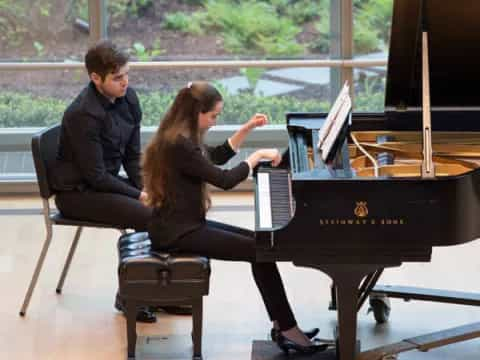 a man and a woman playing piano