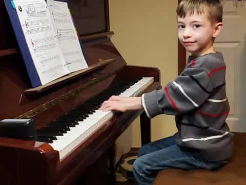a boy playing a piano