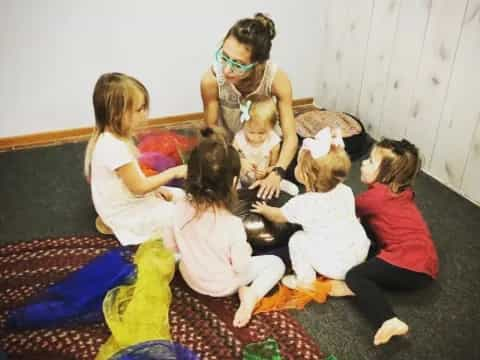 a group of women sitting on the floor with a group of children