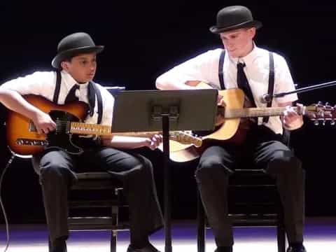 a couple of men playing guitars