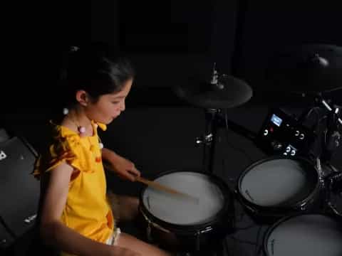 a young girl playing drums