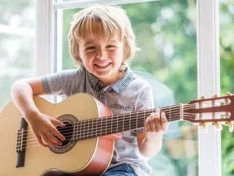 a young girl playing a guitar