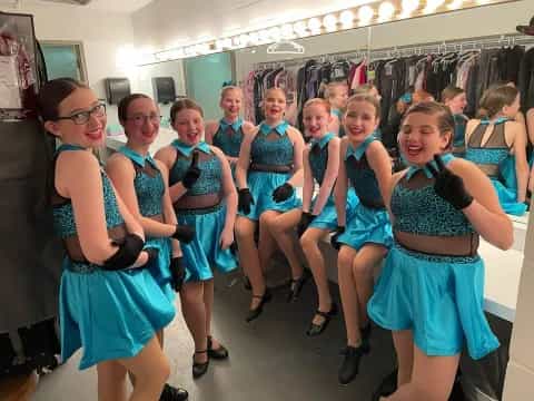 a group of girls in blue dresses