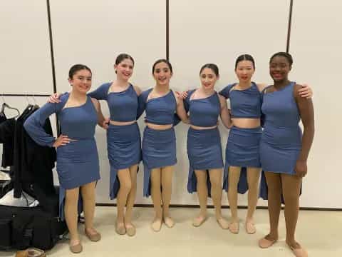 a group of women in blue dresses