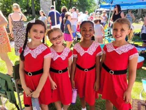 a group of women in red dresses