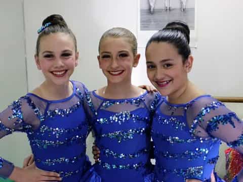 a group of girls in blue dresses