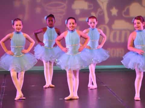 a group of girls in blue dresses