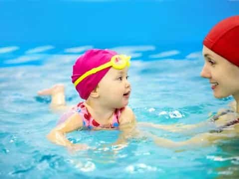 a person and a baby in a pool