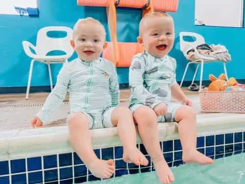 two babies sitting on a chair