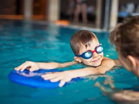 a boy in a pool wearing goggles