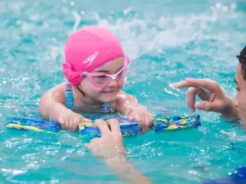 a person and a baby in a pool