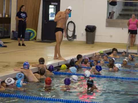 a person in a swimsuit standing on a mat in front of a group of people in a