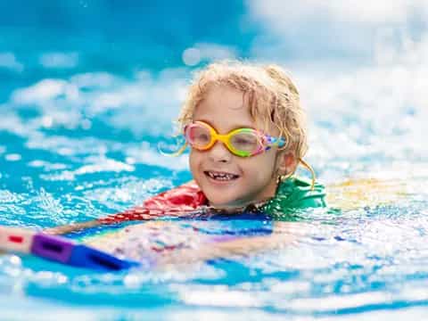 a child in a pool wearing goggles