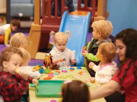 a group of children sitting around a table